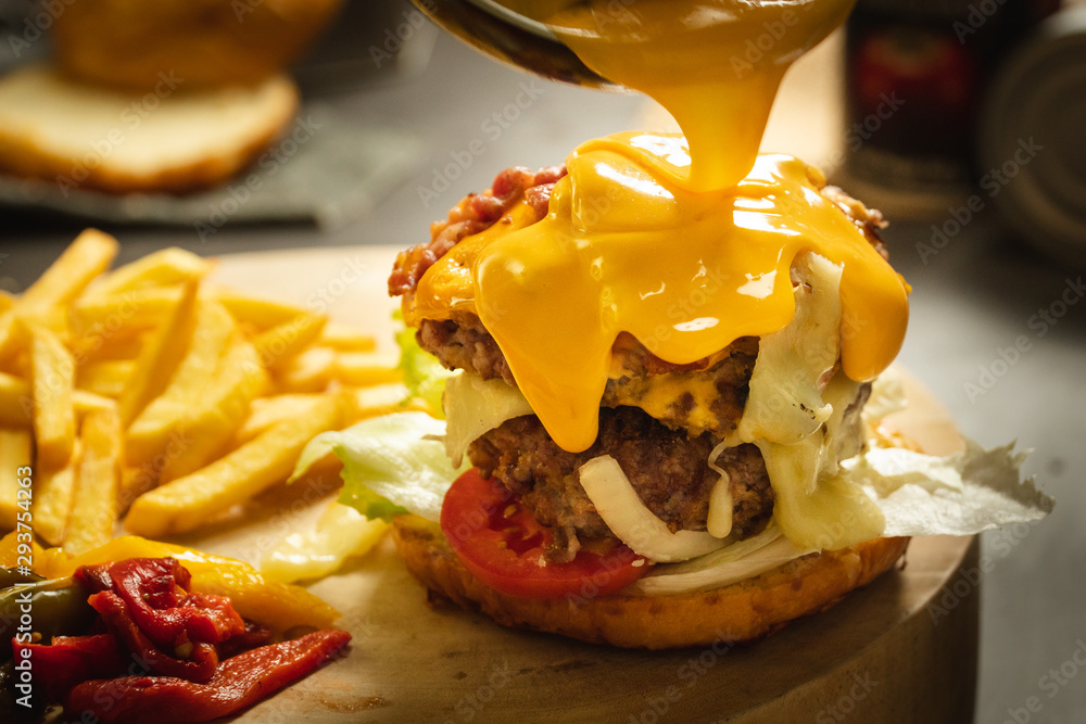 Pour melt cheese on top of Big Double extra cheese burger and potato ...