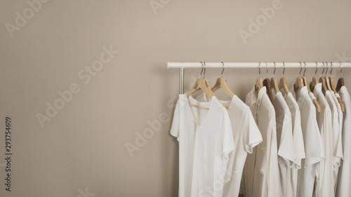 Simple wardrobe with white t-shirts copy space © Freepik