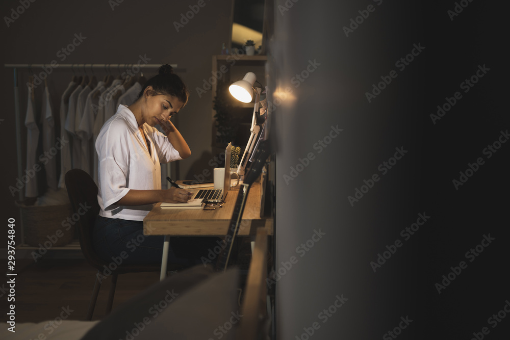 Casual dressed woman sitting on desk