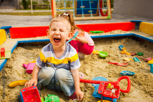 Foto two grubby kids playing in the sandbox