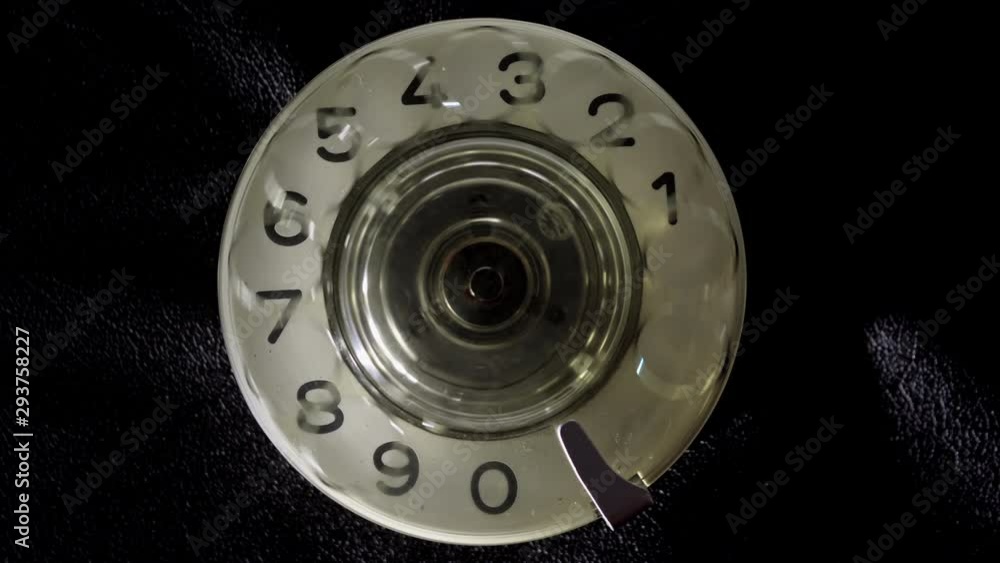 Dialing on an old rotary style telephone. Dialing 911 Emergency phone call. Close-up view. Dialing on an old rotary style telephone. Dialing 911 Emergency phone call. Close-up view.