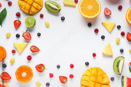 Frame made of ripe fruits and berries on white background photo