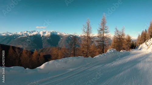 view of a mountain range and a valley from a snowy pathway while following it