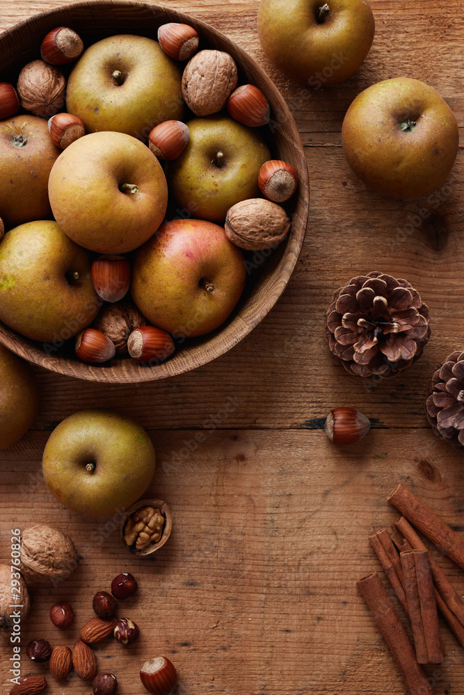 Autumn apples with nuts and cinnamon sticks on table Autumn apples with nuts and cinnamon sticks on table