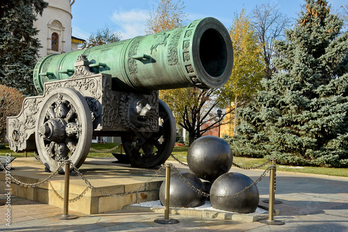 Monument to the Tsar’s cannon in the Kremlin in Moscow. Russia. Clear sunny autumn day, green Christmas trees and yellow trees against a blue sky.