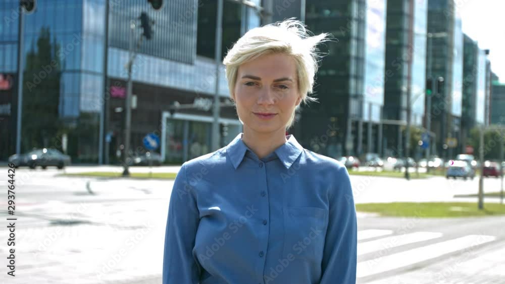 Businesswoman looks direct to camera standing in the city slow motion outdoors Businesswoman looks direct to camera standing in the city slow motion outdoors