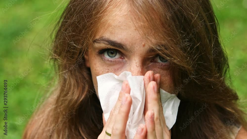 Sick girl with runny nose sneezing hard into tissue. Flu season concept. Sick girl with runny nose sneezing hard into tissue. Flu season concept.