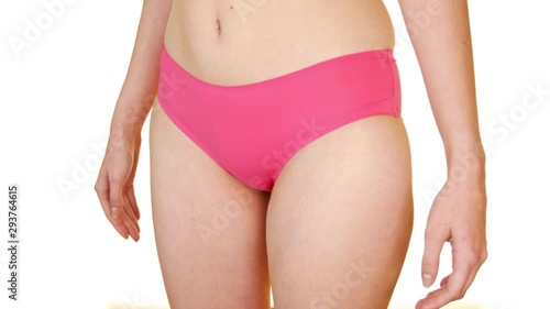 Close up of woman in pink lingerie covering crotch with her hands. White background. photo