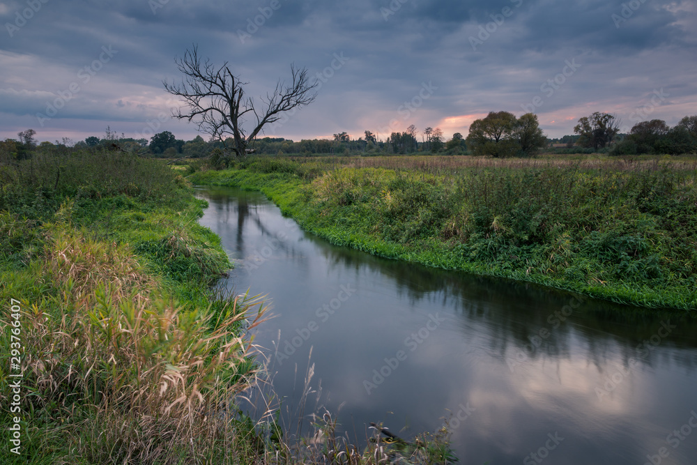 Sunset in the Jeziorka valley at cloudy day, Masovia, Poland Sunset in the Jeziorka valley at cloudy day, Masovia, Poland