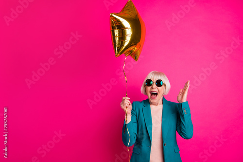 Portrait of her she nice-looking attractive lovely crazy overjoyed cheerful cheery gray-haired lady holding balloon having fun isolated on bright vivid shine vibrant pink fuchsia color background photo