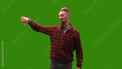 Male model on green screen thumbs down to the left to dissaprove something. Easy chroma keying by just one click is prepared. photo