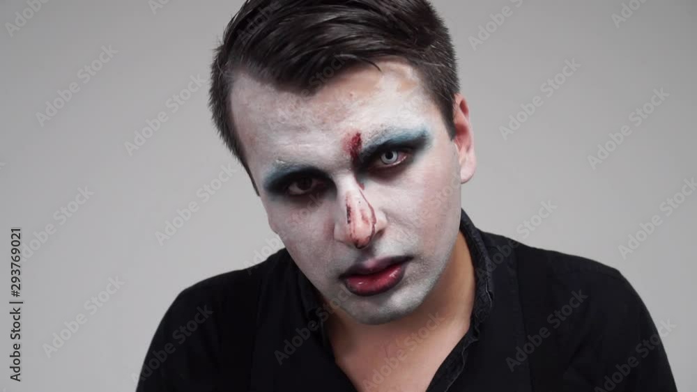 Man with face paint looking at camera and showing tongue, portrait closeup, slowmo Man with face paint looking at camera and showing tongue, portrait closeup, slowmo