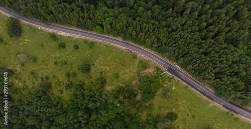 Aerial view over mountain road going through forest landscape. Transylvania, Romania © pelinoleg
