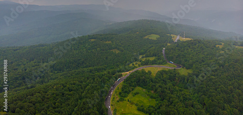 Aerial view over mountain road going through forest landscape. Transylvania  Romania