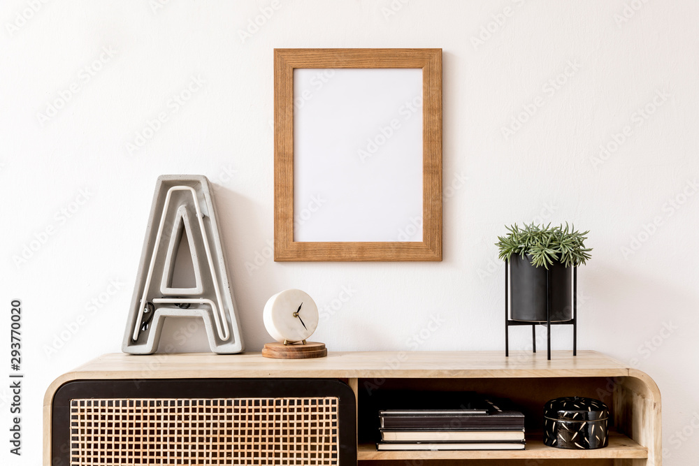 Obraz Modern interior design with mock up photo frame, wooden commode, books, plant, big letter, white clock and elegant accessories. Stylish home decor. Template. Mockup ready to use.