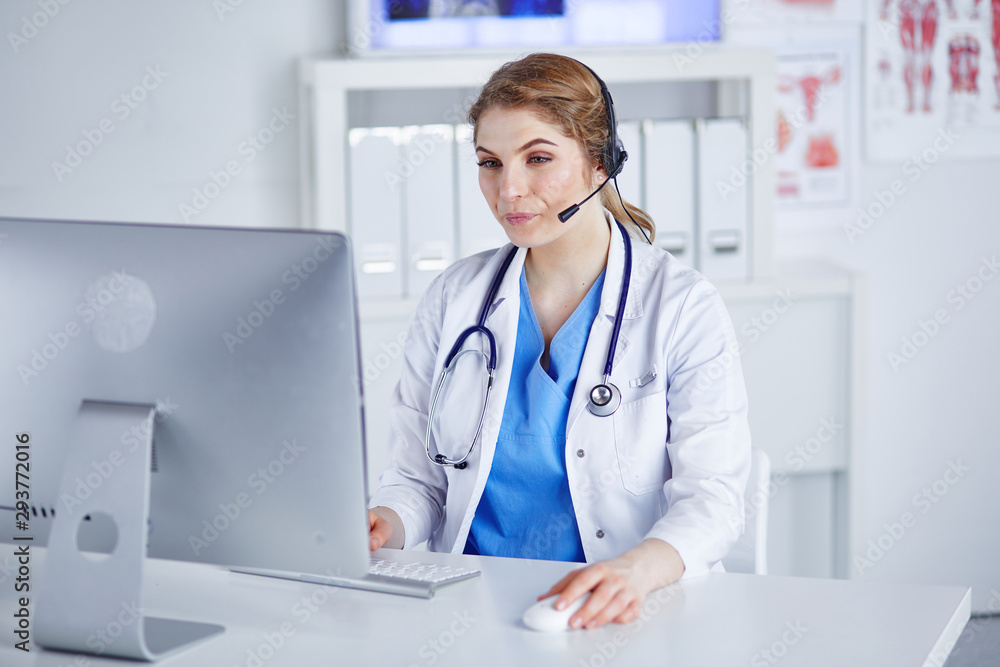 Portrait of a happy smiling young doctor in headset in office Portrait of a happy smiling young doctor in headset in office