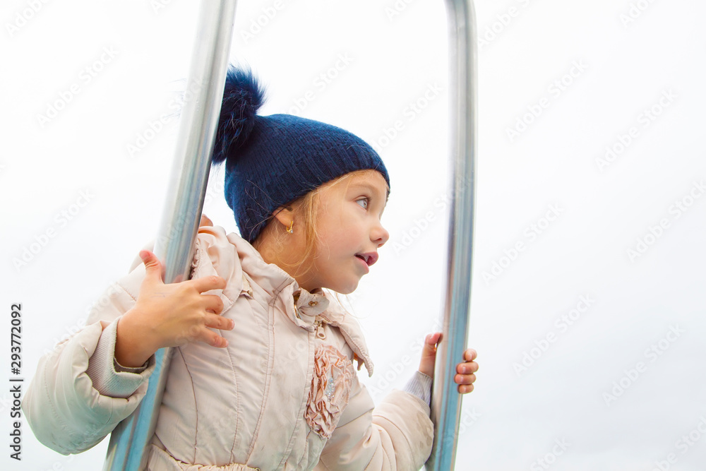 girl in autumn clothes spins and balances on modern metal carousel girl in autumn clothes spins and balances on modern metal carousel