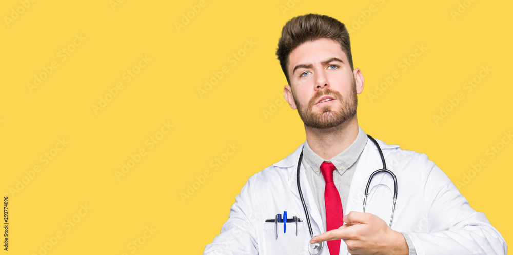 Young handsome doctor man wearing medical coat In hurry pointing to watch time, impatience, upset and angry for deadline delay Young handsome doctor man wearing medical coat In hurry pointing to watch time, impatience, upset and angry for deadline delay