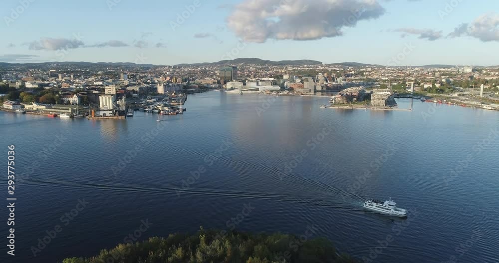 Cinema 4K drone shot with forward tilt reveal motion of Hovedøya island, a ferry, the Oslofjord and the Bjørvika project with the Lambda Munch Museum and Opera House in autumn fall, in Oslo Norway. Cinema 4K drone shot with forward tilt reveal motion of Hovedøya island, a ferry, the Oslofjord and the Bjørvika project with the Lambda Munch Museum and Opera House in autumn fall, in Oslo Norway.