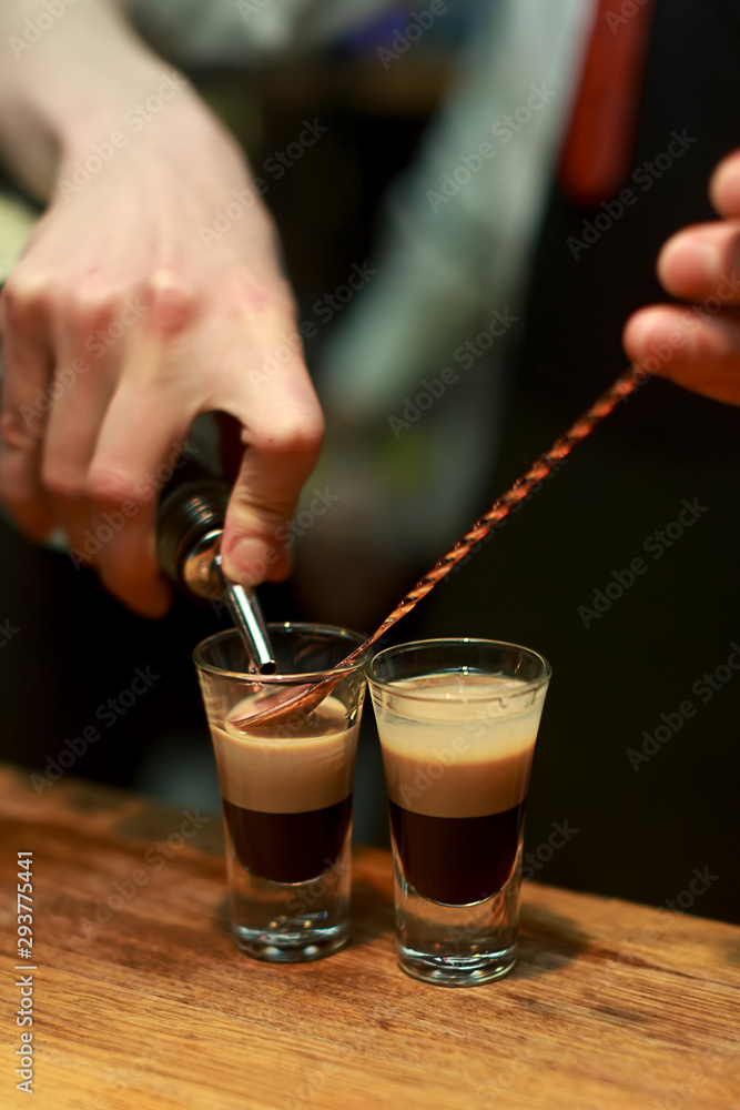 Barman make alcoholic shots with rum and liquor Barman make alcoholic shots with rum and liquor