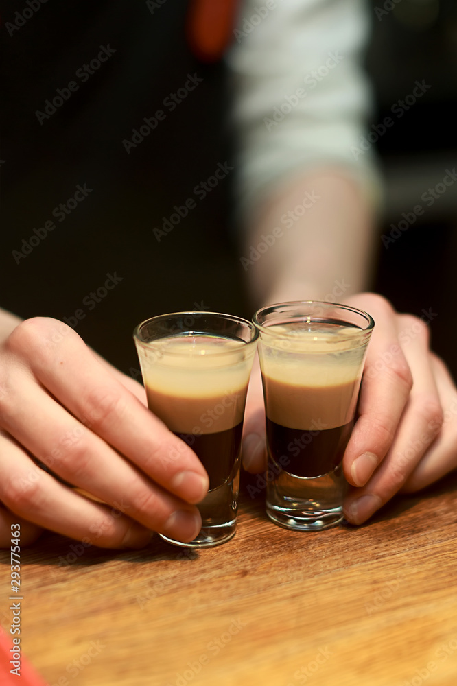 Barman make alcoholic shots with rum and liquor Barman make alcoholic shots with rum and liquor