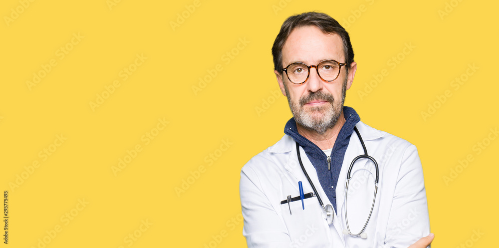Handsome middle age doctor man wearing medical coat with serious expression on face. Simple and natural looking at the camera. Handsome middle age doctor man wearing medical coat with serious expression on face. Simple and natural looking at the camera.
