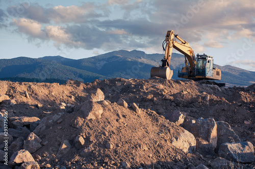 Excavator moving stone and earth photo