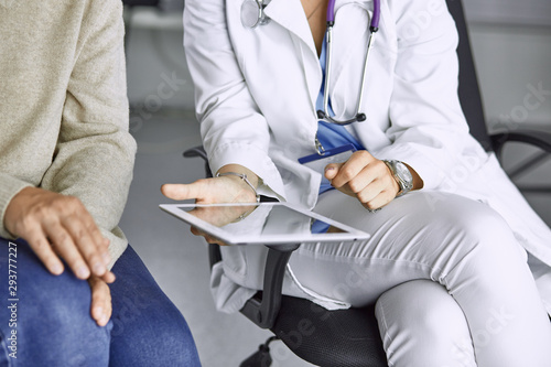 female doctor talking to a patient on a tablet