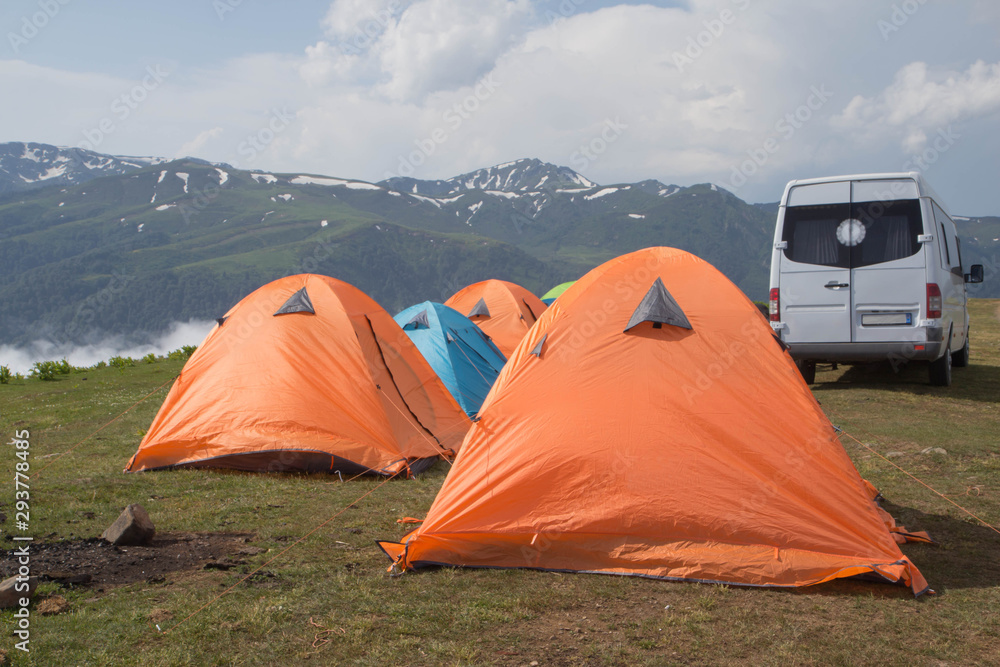 tents in the mountains. Orange camping tent in a morning light