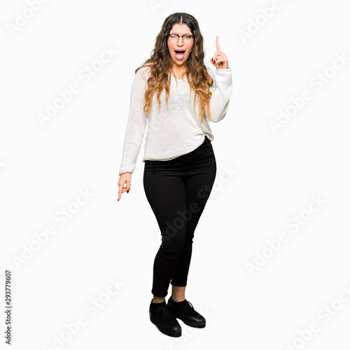 Young beautiful woman wearing glasses pointing finger up with successful idea. Exited and happy. Number one.