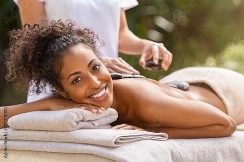 Woman having massage with hot stones at spa photo