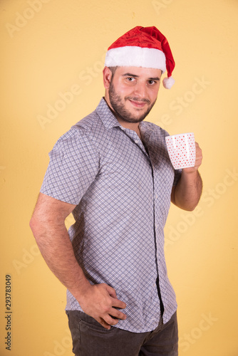 Hombre de oficina tomando cafe con gorro de navidad 
