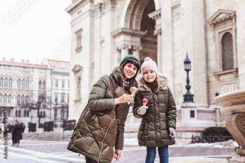 Family eats ice cream rose near St. Stephen Basilica. Famous place in Budapest