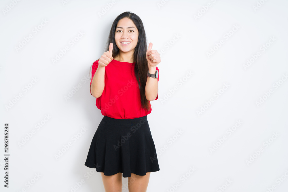 Beautiful brunette woman wearing red t-shirt and skirt over isolated background approving doing positive gesture with hand, thumbs up smiling and happy for success. Looking at the camera Beautiful brunette woman wearing red t-shirt and skirt over isolated background approving doing positive gesture with hand, thumbs up smiling and happy for success. Looking at the camera