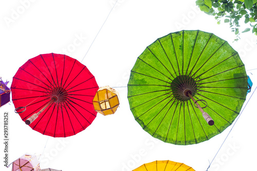 Green and red umbrella hanging on a rope with lanterns during Yi Peng Festival in northern Thailand.