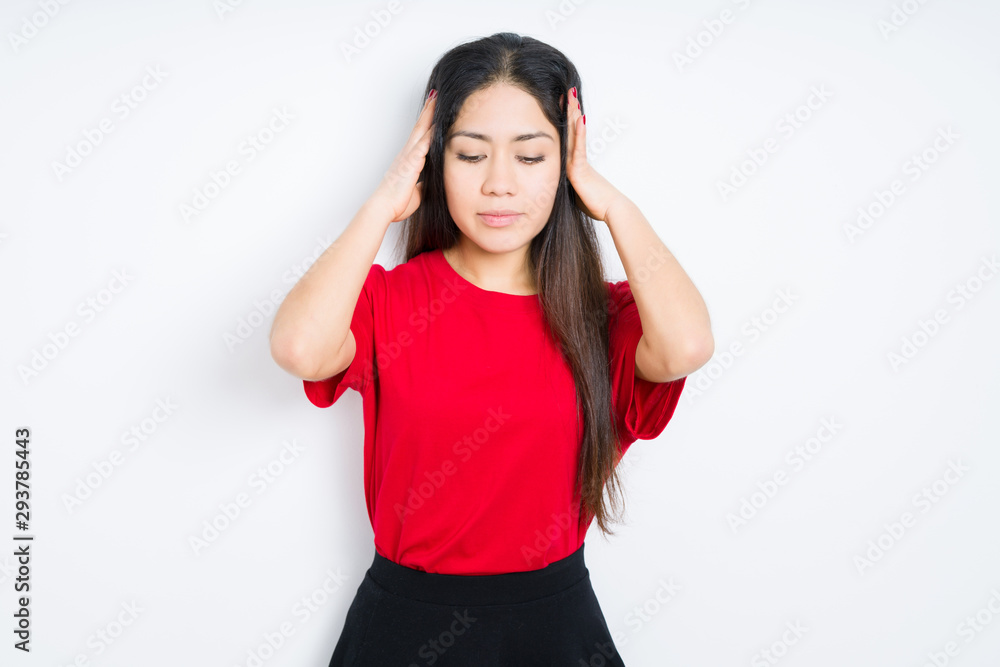 Beautiful brunette woman wearing red t-shirt over isolated background suffering from headache desperate and stressed because pain and migraine. Hands on head.
