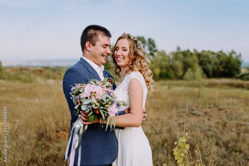 Wedding couple smiling. Beautiful bride and groom. Groom's boutonniere and bride’s wedding bouquet in hands. Wedding couple smiling. Beautiful bride and groom. Groom's boutonniere and bride’s wedding bouquet in hands.