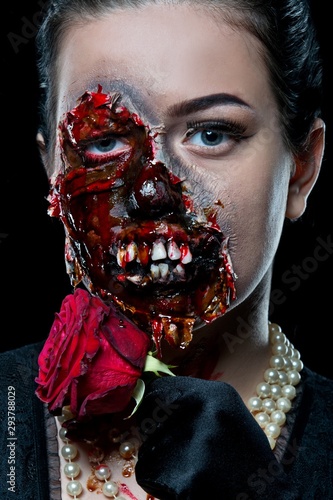 Woman with horror make up in the studio on a black background. Halloween make up. Zombie.