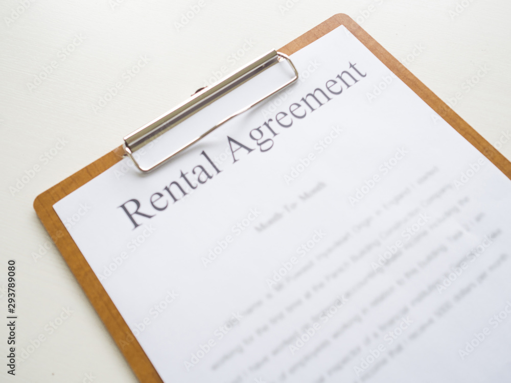 A car rental service lease contract on wooden clipboard A car rental service lease contract on wooden clipboard