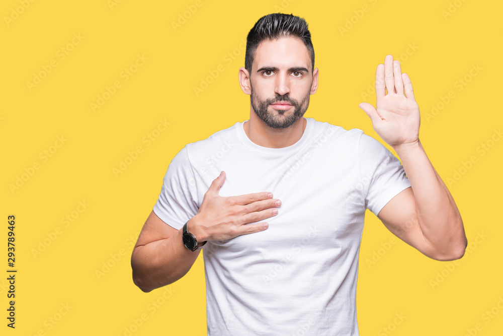 Handsome man wearing white t-shirt over yellow isolated background Swearing with hand on chest and open palm, making a loyalty promise oath Handsome man wearing white t-shirt over yellow isolated background Swearing with hand on chest and open palm, making a loyalty promise oath