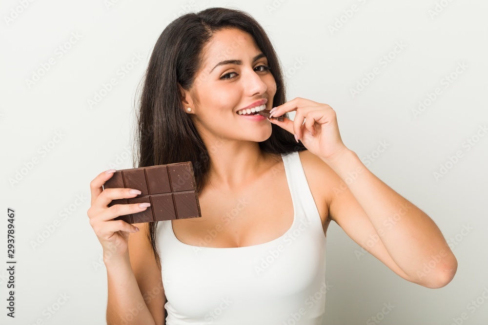 Young hispanic woman holding a chocolate tablet Young hispanic woman holding a chocolate tablet