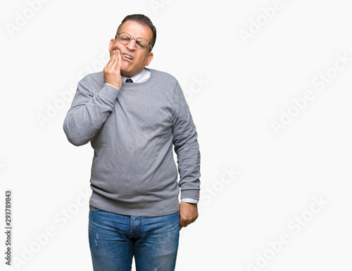 Middle age bussines arab man wearing glasses over isolated background touching mouth with hand with painful expression because of toothache or dental illness on teeth. Dentist concept.