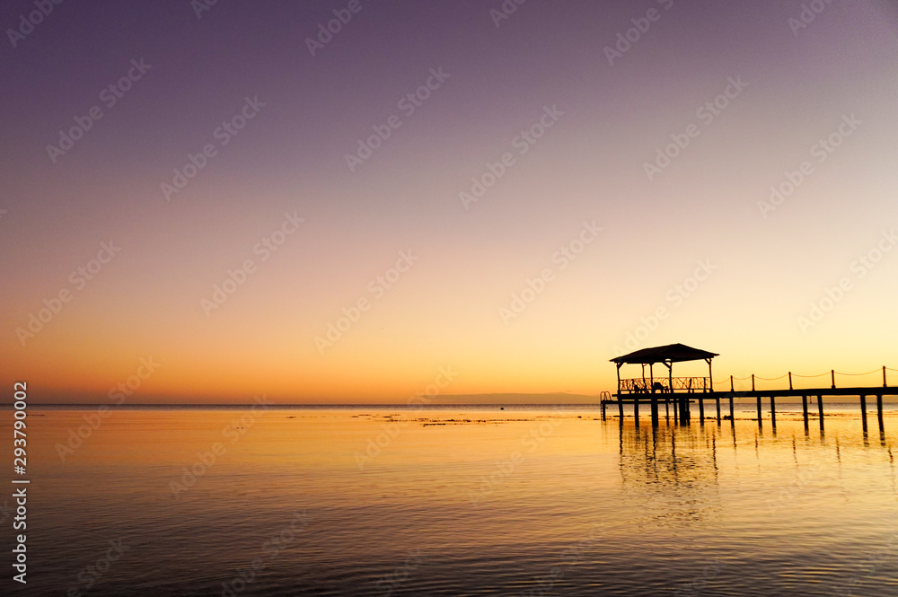 A dock over water at sunset on the island of Fakarava in French Polynesia in the South Pacific
