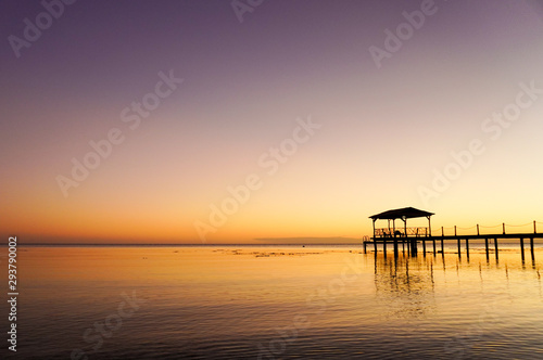 A dock over water at sunset on the island of Fakarava in French Polynesia in the South Pacific