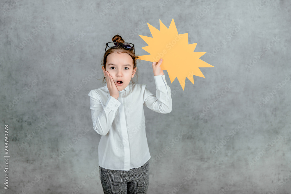 Young girl holding speech bubble on gray background Young girl holding speech bubble on gray background