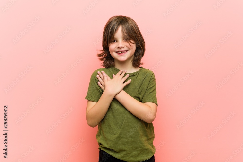 Little boy has friendly expression, pressing palm to chest. Love concept. Little boy has friendly expression, pressing palm to chest. Love concept.