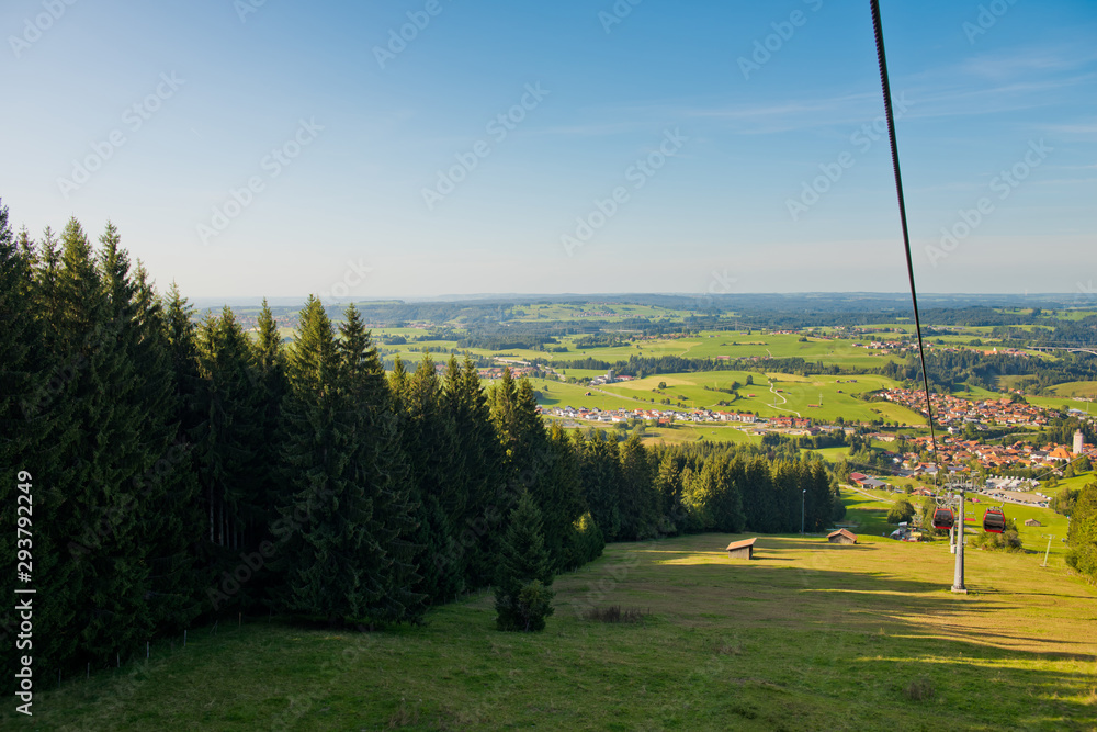 Mountain landscape with forest and ski lift on a sunny day.