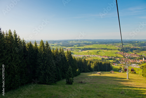 Mountain landscape with forest and ski lift on a sunny day.