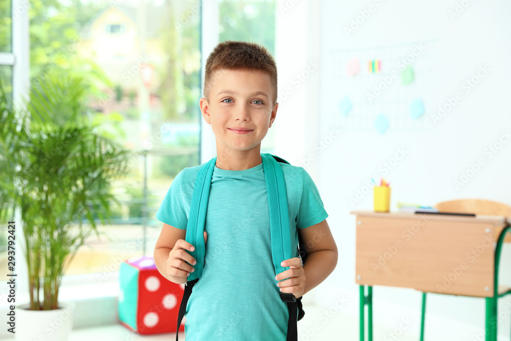 Cute little boy with backpack in classroom at school Cute little boy with backpack in classroom at school