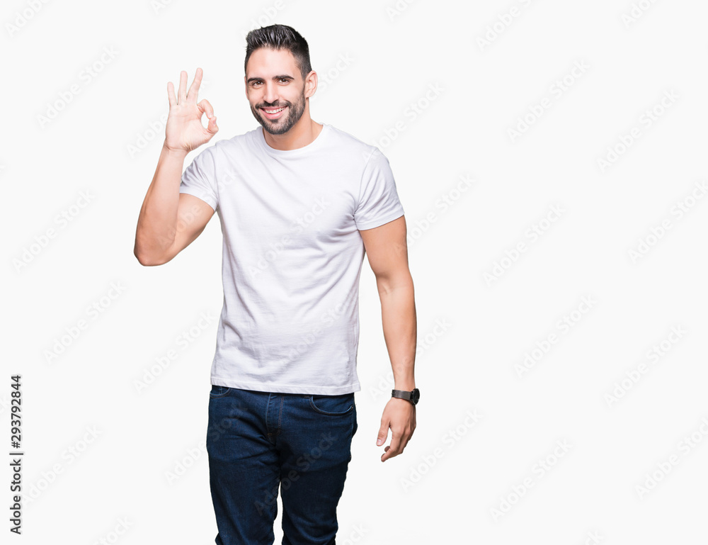 Young man wearing casual white t-shirt over isolated background smiling positive doing ok sign with hand and fingers. Successful expression. Young man wearing casual white t-shirt over isolated background smiling positive doing ok sign with hand and fingers. Successful expression.